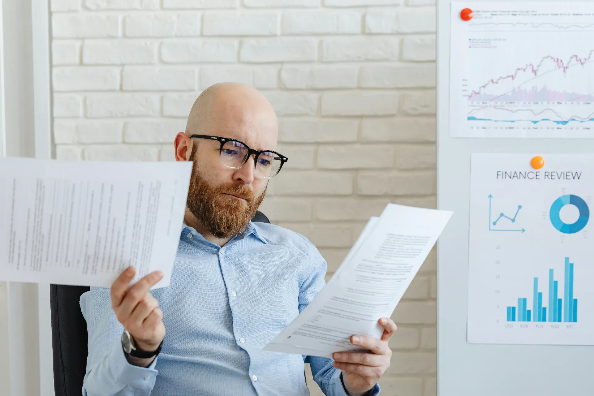 Man contemplating printed reports for nonprofit operation.