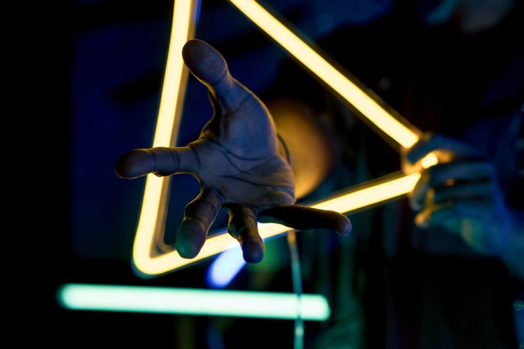 Helping hand stretching through a lighted triangle symbolizing expert help
