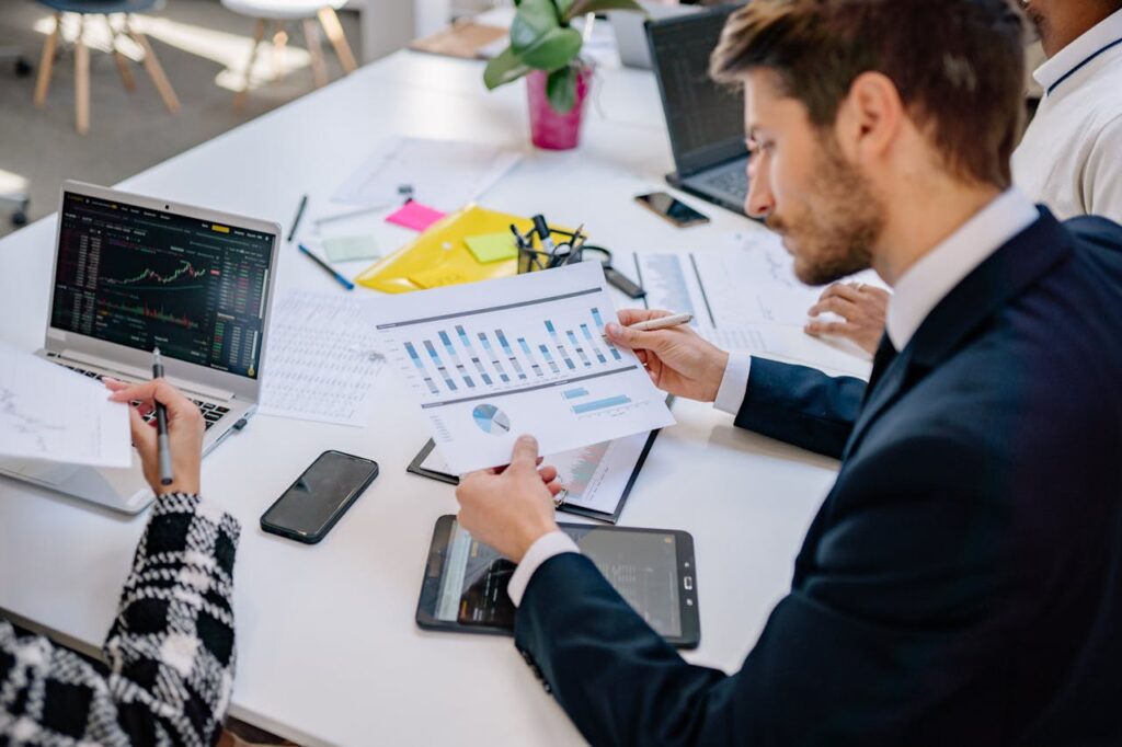 People looking at graphs and printouts to compare on-premise vs cloud ERP implementations