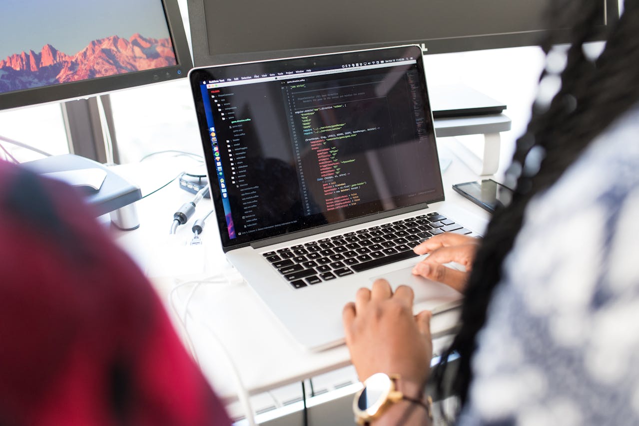 person writing code on laptop
