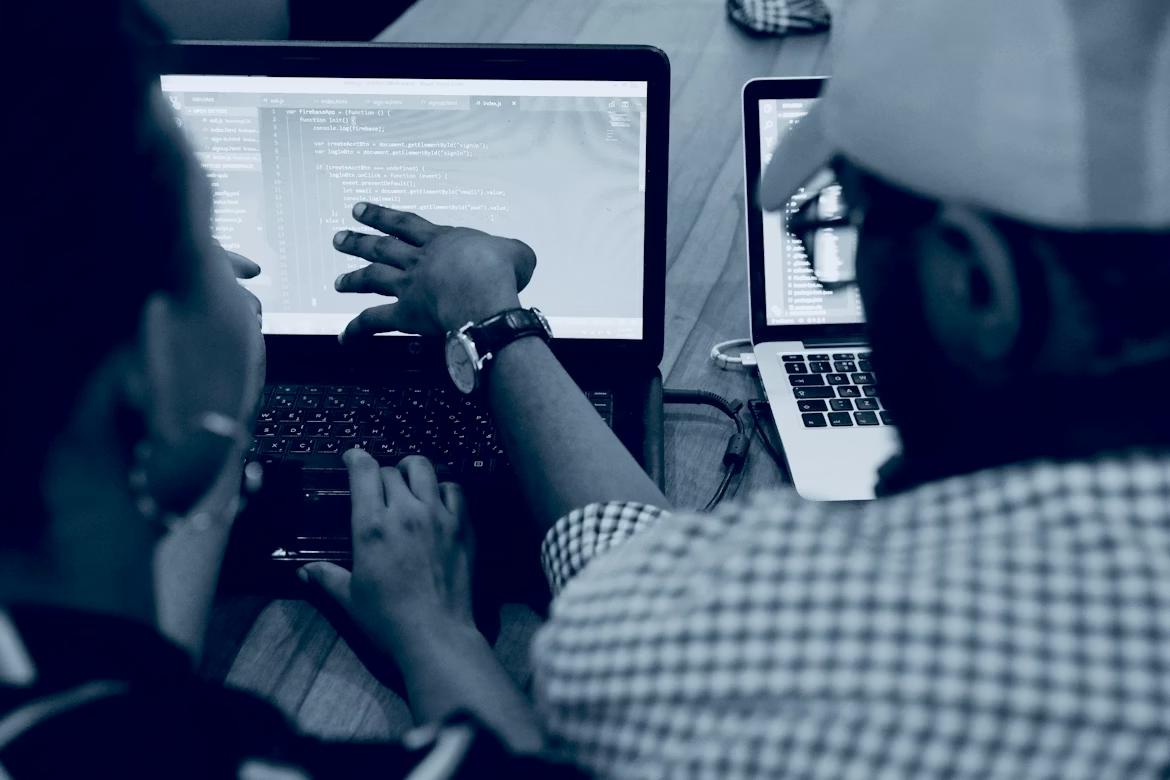 Two colleagues collaborating on software development project using laptop computer